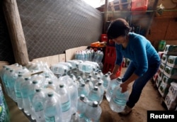 Carolina Maldonado stores bottled water due to water scarcity in Paine, Chile.