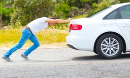 man pushing a car