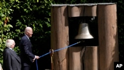 US President Joe Biden rings the peace bell accompanied by his counterpart Irish President Michael Higgins at Aras an Uachtarain, the presidential residence, on April 13, 2023 in Dublin.