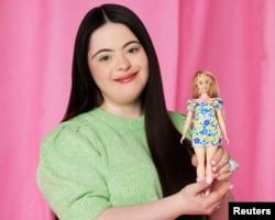 British model Ellie Goldstein poses with the first Barbie doll with Down syndrome, in London, Britain.  Mattel/Catherine Harbour/Handout via REUTERS