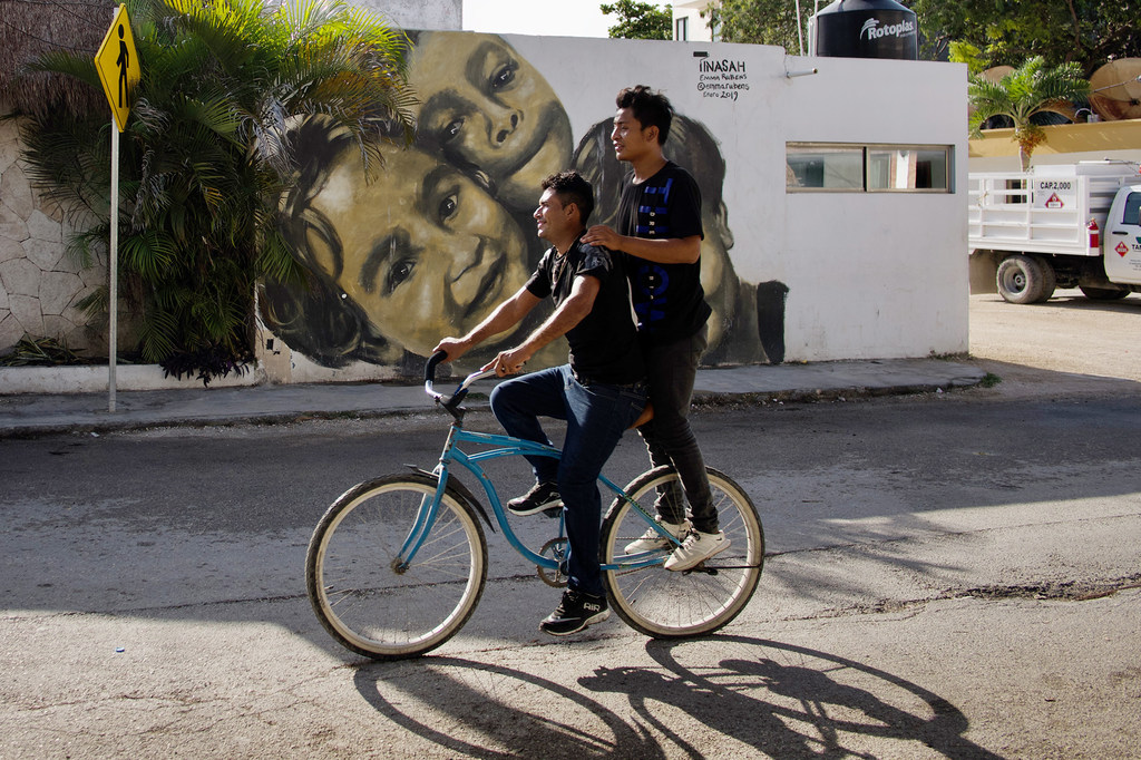 Some friends ride the streets of Mexico on bicycles.