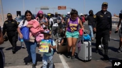 Venezuelan migrants are escorted by Peruvian police to a migration office on the border with Chile in Tacna, Peru, on April 28, 2023.