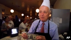 Los Angeles Mayor Richard Riordan receives a tip from a customer at his restaurant "The Pantry"on Friday, June 29, 2001 in downtown Los Angeles.