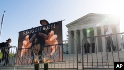 An abortion rights activist holds a banner in front of the US Supreme Court, Wednesday, April 19, 2023, in Washington.  (AP Photo/Manuel Balce Cenata)