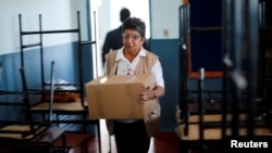 An official from Paraguay's Superior Court of Electoral Justice moves a box containing a voting machine to a public school, which will be a voting center, one day before the presidential elections, in Asuncion, Paraguay, April 29, 2023. REUTERS/Agustin Marcarian