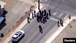 Police officers in the area where an armed teenager killed three people in New Mexico.  (Video capture from Reuters)