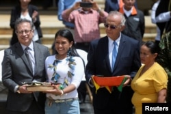 Colombian Defense Minister Iván Velásquez (R) and President Gustavo Petro pose for a photo with women who helped rescue surviving children from a plane that crashed in the thick Colombian jungle, on 26 June 2023. REUTERS/Vannessa Jimenez