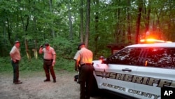 Authorities guard the entrance to Mine Bank Trail, a rescue operation access point along the Blue Ridge Parkway where a Cessna Citation crashed into mountainous terrain near Montebello, Virginia, on Sunday, June 4, 2023. (Randall K. Wolf via AP)