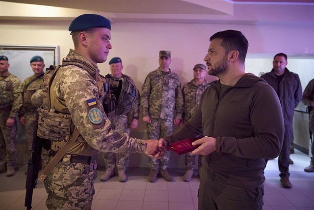 Ukrainian President Volodimir Zelensky decorates a soldier.