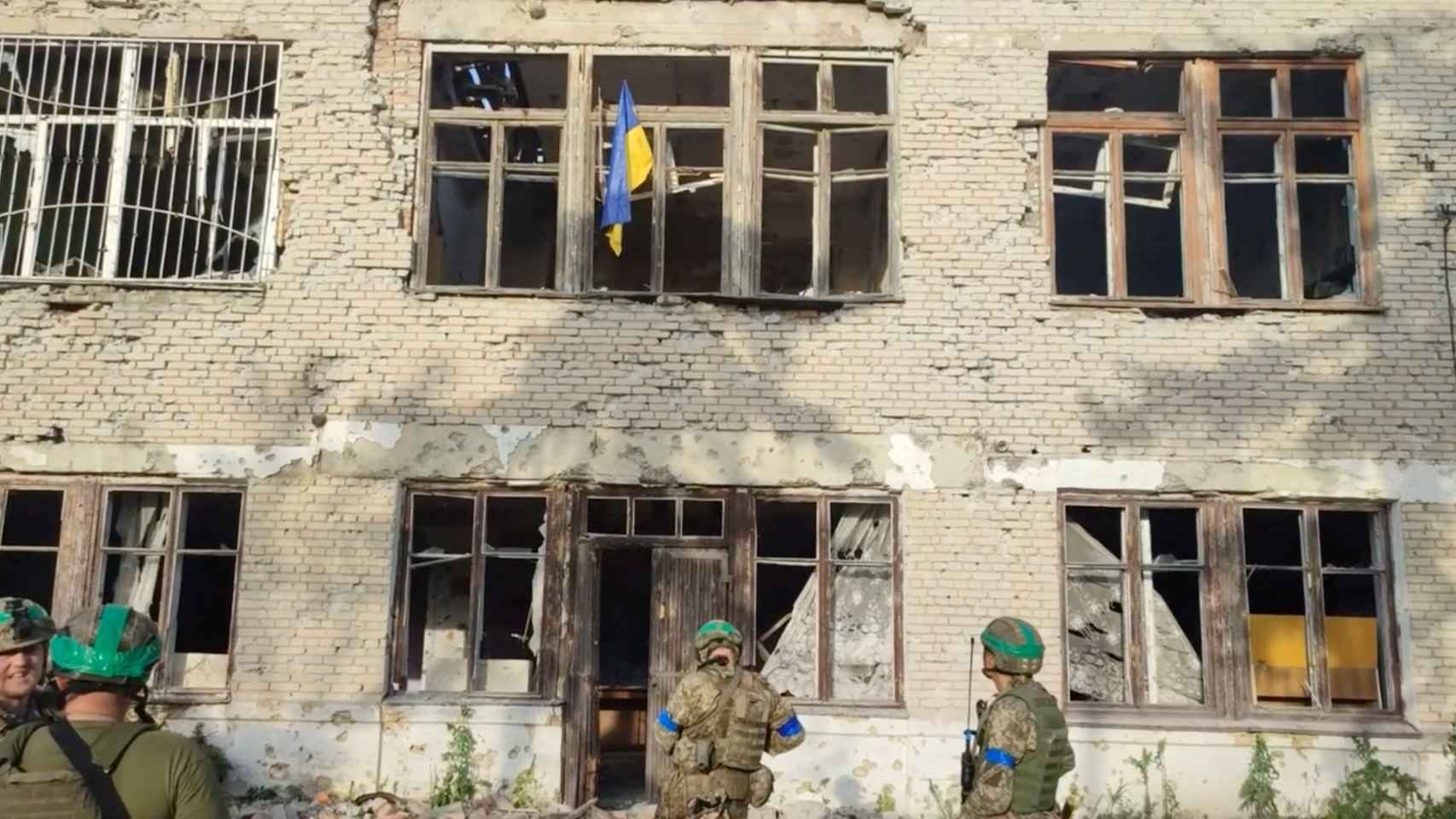 Ukrainian soldiers raise the flag in a retaken village.