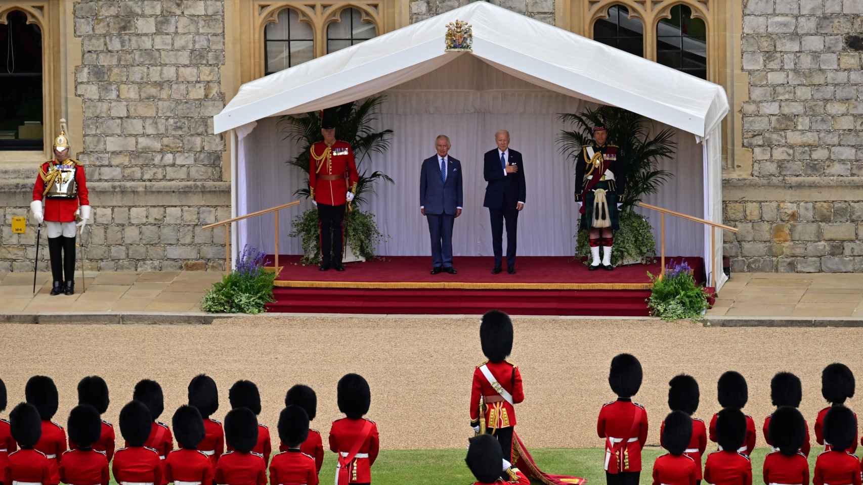 US President Joe Biden , and Britain's King Charles on the dais, listen to the US National Anthem played by the Welsh Guards Band.