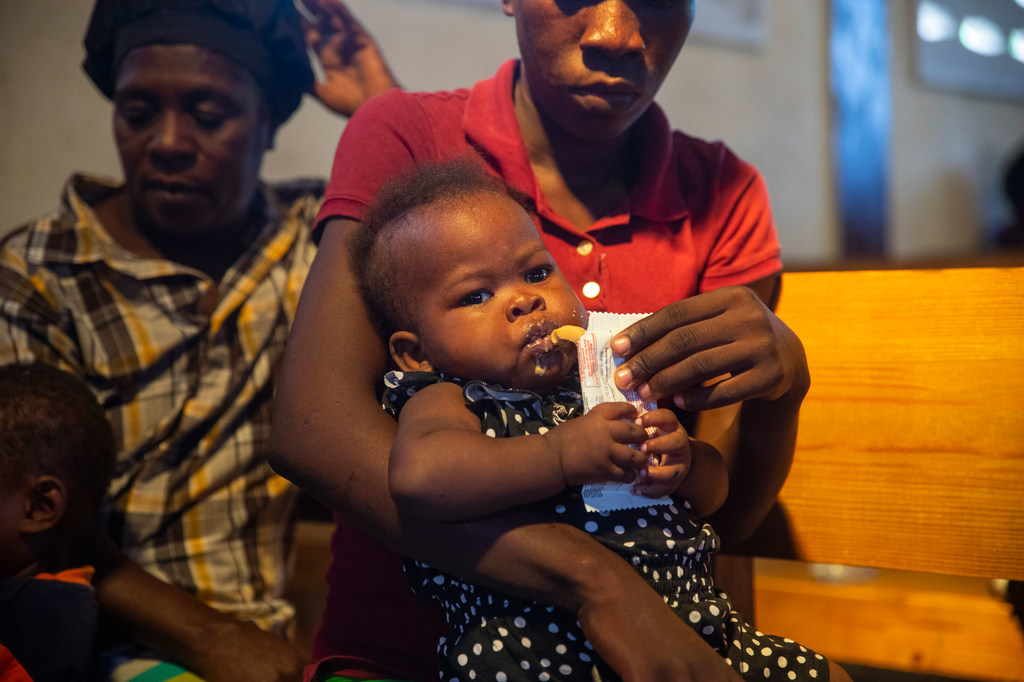 A Haitian child with severe acute malnutrition taking a nutritional supplement.