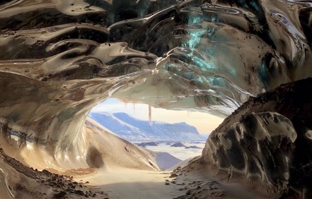 Glacier cave in Svalbard, Norway, formed by large volumes of glacial meltwater flowing through it during the summer.