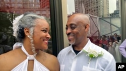 Hazel Seivwright-Carney and her husband, Rohan Carney, smile at each other, at Lincoln Center in New York, on Saturday, July 8, 2023. The couple came to renew their vows in a mass wedding on Saturday, after eloped 28 years earlier.