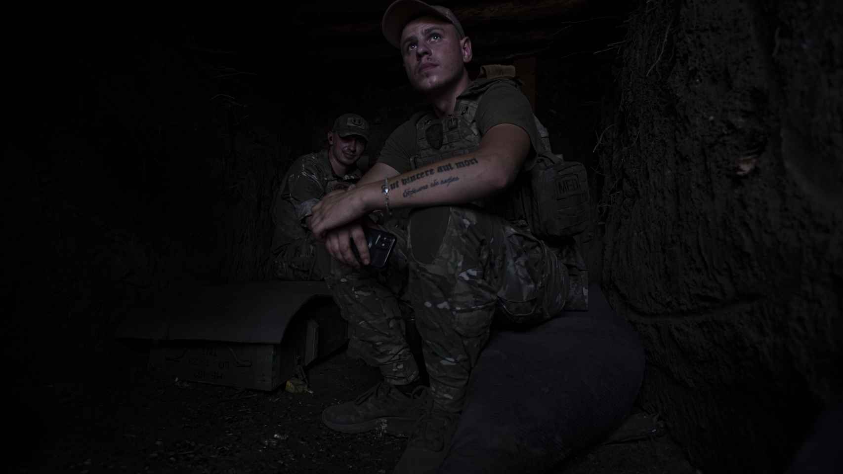 Two soldiers from the 80th Airborne Brigade of the Ukrainian Army wait in their trench, on the Bakhmut frontline