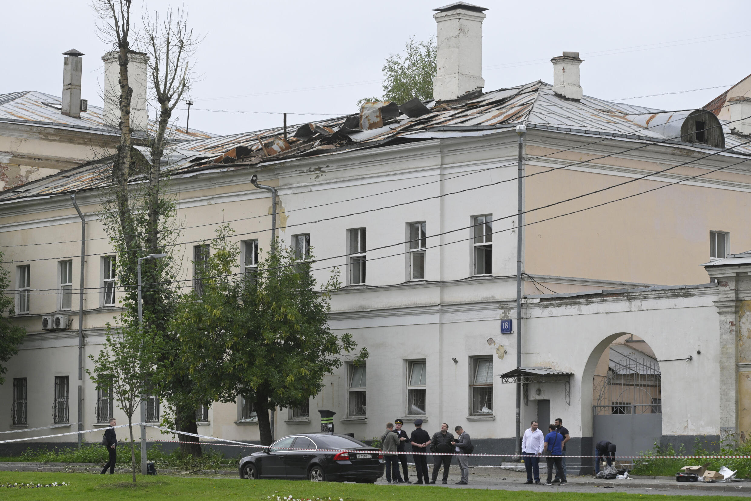 Investigators examine an area next to a damaged building after a reported drone strike in Moscow, Russia, Monday, July 24, 2023.