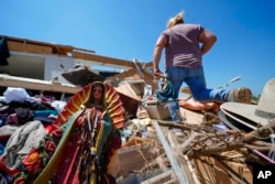 A statue of the Virgin of Guadalupe lies in the rubble of the destroyed home of Juana Landeros, who weathered a deadly tornado with her husband and 9-year-old son the night before, Sunday, May 26, 2024, in Valley View, Texas , USA.