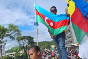 A protester waves the Azerbaijani flag next to a Kanak flag on May 16 in Noumea.