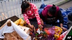 Women collect discarded products at the central fruit and vegetable market in Buenos Aires, Argentina, on Friday, May 10, 2024.