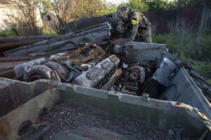 An International Legion soldier inspects the remains of a Russian armored vehicle in Bilohorivka.