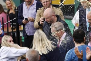 A young woman throws a milkshake in the face of populist Nigel Farag