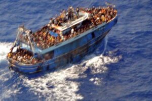 Migrants aboard a boat during a rescue operation before their boat capsized in the open sea.