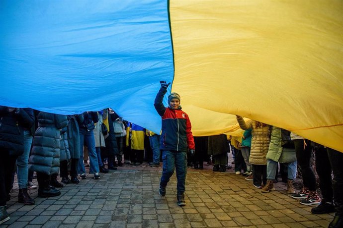 File - February 24, 2024, Vilnius, Lithuania: A kid goes under a giant Ukrainian flag during a rally in support of Ukraine.  A march and demonstration in support of Ukraine attended by about 1,000 people took place in Vilnius on the second anniversary o