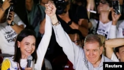 Edmundo González Urrutia, presidential candidate of the Unitary Platform in Venezuela, raises his hand alongside leader María Corina Machado, at the closing event of the campaign in Caracas, on July 25, 2024.
