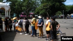 People queue to buy vegetables at a market set up by the government as part of a plan to reverse rising food prices in Santa Tecla, El Salvador.