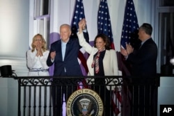 President Joe Biden and Vice President Kamala Harris hold hands as they arrive to watch the Fourth of July fireworks from the balcony of the White House in Washington, Thursday, July 4, 2024. (AP Photo/Susan Walsh)