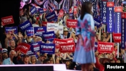 Attendees hold signs in support of former President Donald Trump and his presidential running mate JD Vance as former U.S. Ambassador to the UN Nikki Haley speaks at the Republican National Convention, in Milwaukee, Wisconsin, July 16, 2024.