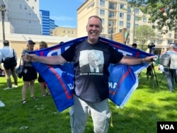 A Donald Trump supporter wears a T-shirt with the former president's mugshot during a vigil in Milwaukee to pray for the health and safety of the Republican presidential candidate, who was the victim of an attack the previous day at a campaign rally.