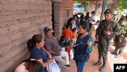 This photo released by the Presidency of Guatemala shows a social worker speaking with Mexican citizens at a temporary shelter in a school in Nueva Reforma, Huehuetenango, Guatemala, July 27, 2024.