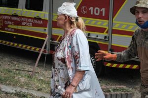 A nurse at a children's hospital in kyiv, with a head wound and blood on her clothes, tries to help after the Russian attack.