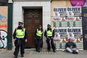 Police officers stand guard during the Notting Hill Carnival parade in London.