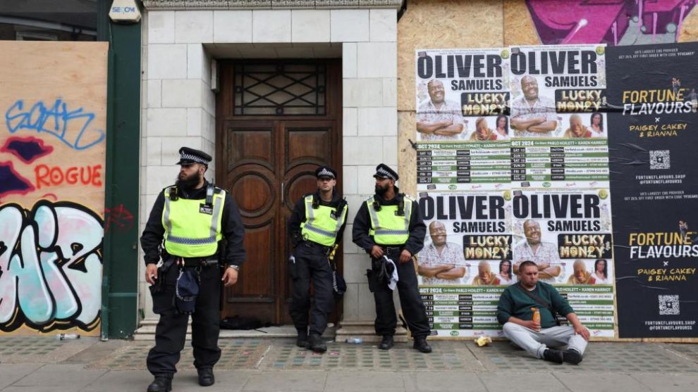 Police officers stand guard during the Notting Hill Carnival parade in London.