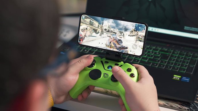 Person playing a video game on mobile with a controller