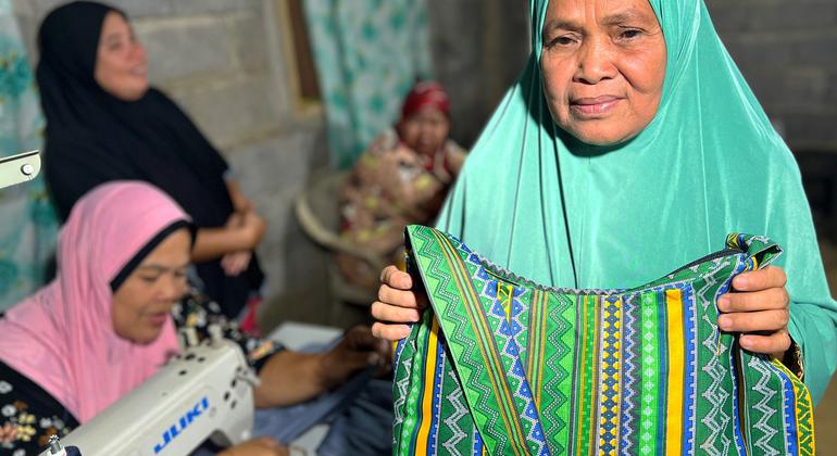 Asnia Dalan shows a bag she sewed after the training she received at the cooperative.