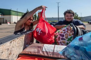 Firefighters evacuated Tanisha Edison and her boyfriend Mason Bruneau check their belongings at the evacuation center in St. Albert, Alberta, on August 16.