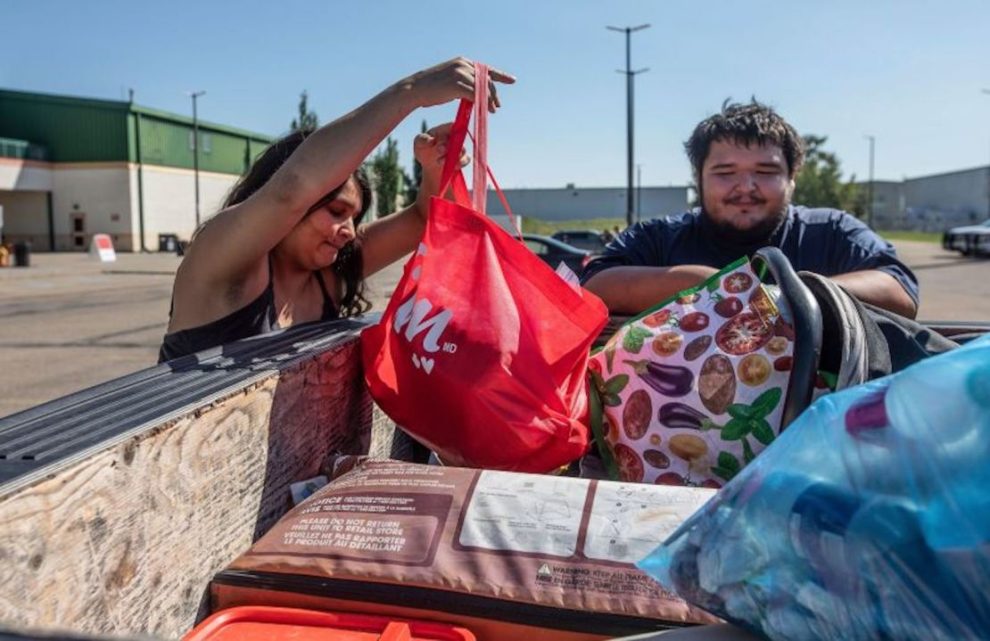 Firefighters evacuated Tanisha Edison and her boyfriend Mason Bruneau check their belongings at the evacuation center in St. Albert, Alberta, on August 16.