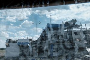 Bombed buildings in Russia's Kursk region, seen through the window of an armored vehicle.