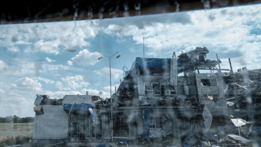 Bombed buildings in Russia's Kursk region, seen through the window of an armored vehicle.