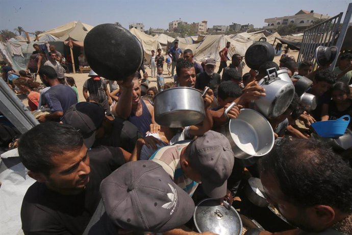 Displaced Palestinians in the Gaza Strip crowd for aid in Deir el-Bala