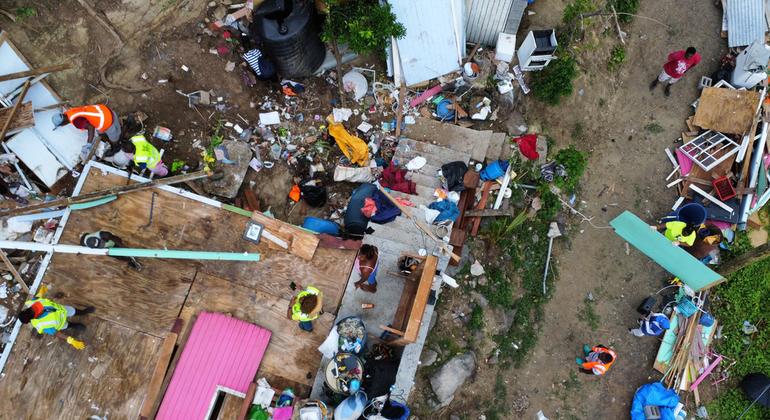 Aerial view of a group of volunteers diligently cleaning up the remains of Rose's house.