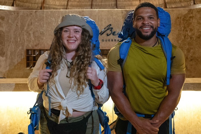 Kola and Mary Ellen stood side by side, smiling, with blue backpacks on their backs.