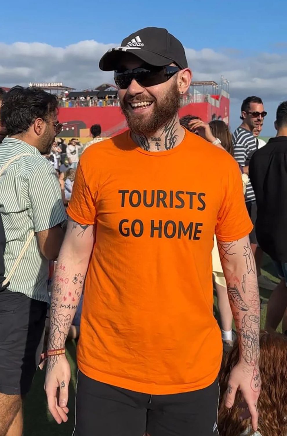 Carlos Ramírez, a 26-year-old teacher, attends the Primavera Sound music festival in Barcelona, ​​Spain, wearing a t-shirt that says “Tourists are going home.”