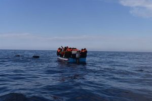 File - Migrants in a wooden boat, who left the coast of Libya, wait to be rescued by members of the NGO Open Arms, on March 5, 2022, off the coast of Libya, in the Mediterranean Sea.