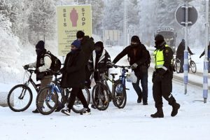 Finnish border guards and migrants with bicycles at the Salla international border crossing in Finnish Lapland on November 21, 2023.