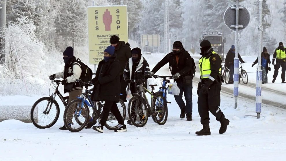 Finnish border guards and migrants with bicycles at the Salla international border crossing in Finnish Lapland on November 21, 2023.