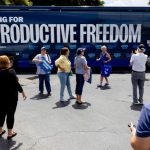 People take photos of the Reproductive Freedom Bus during the kickoff of the Harris-Walz campaign's reproductive rights bus tour in Boynton Beach, Florida, on Sept. 3.